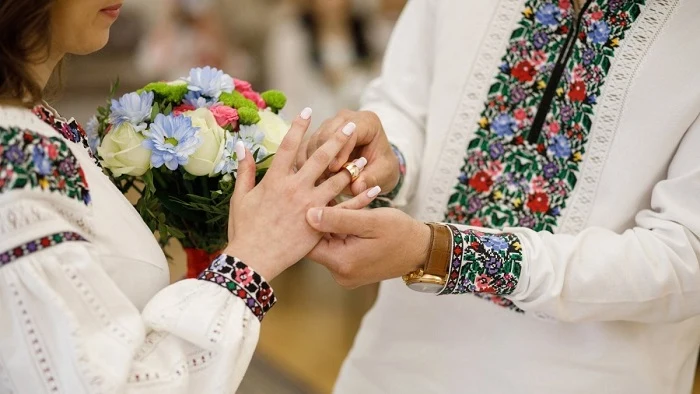 Чоловік і жінка обмінюються обручками в українських вишиванках