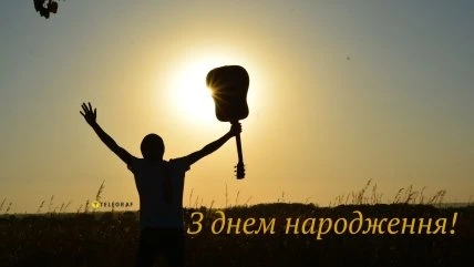 Чоловік з гітарою на фоні заходу сонця, вітання з днем народження.