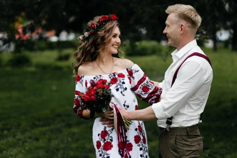 Чоловік і жінка в українському одязі стоять на траві