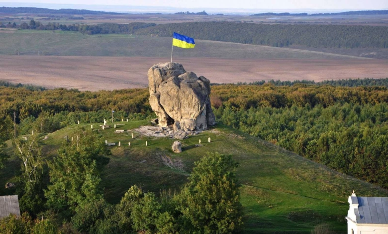 Український прапор на скелі серед полів та лісу
